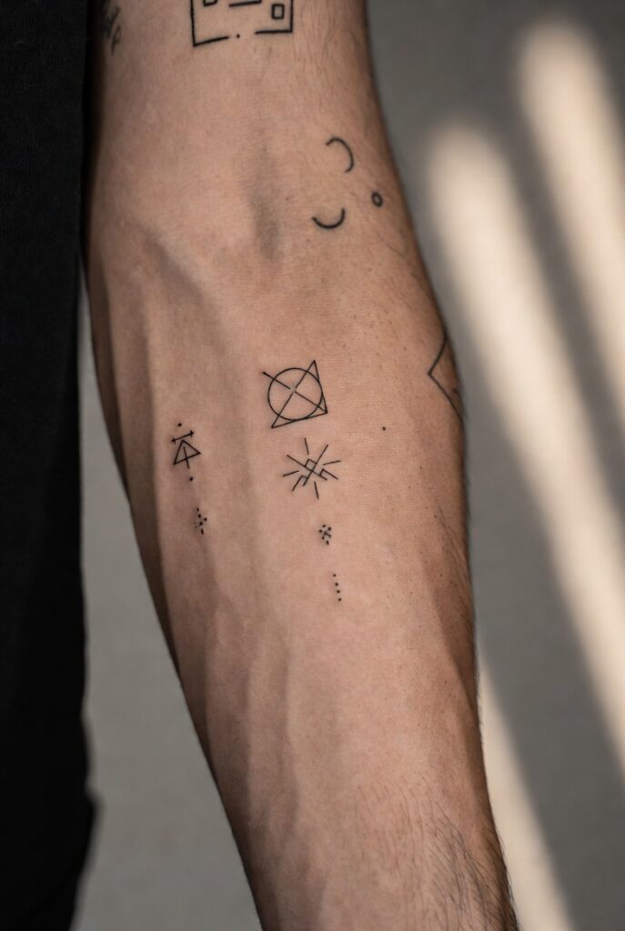 "17 small tattoo ideas for men featuring minimalist designs like compass, mountain, and geometric tattoos worth the needle."