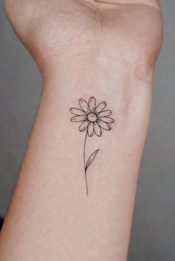 Simple and stunning daisy tattoo ideas featuring fine-line, watercolor, and black-and-grey designs on skin — creative daisy tattoo inspiration."